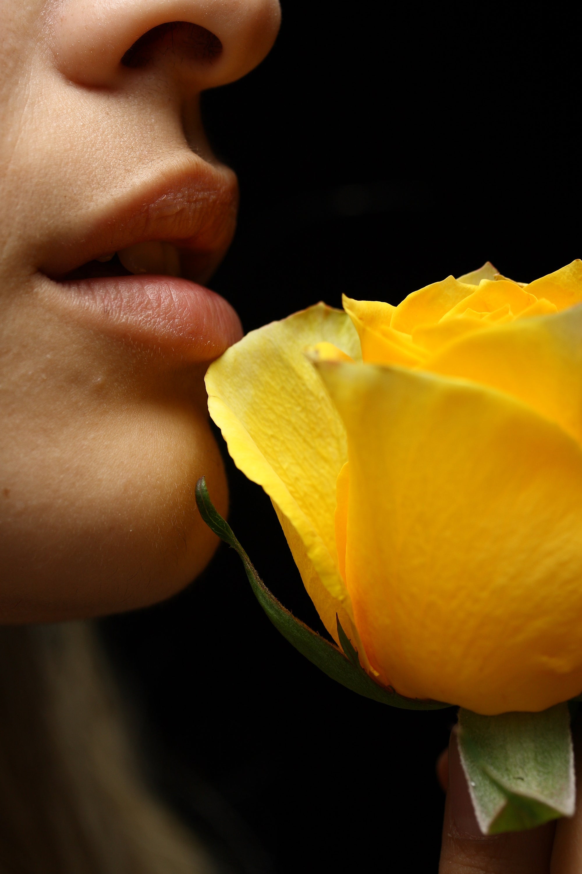 Visage d'une femme proche d'une fleur jaune